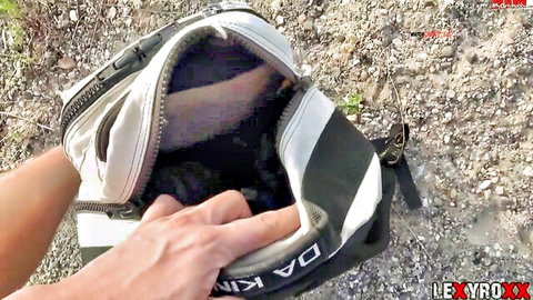 LexyRoxx teases with open backpack revealing secrets outdoors