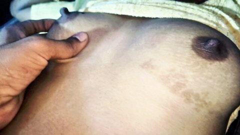 Dark hand groping and pinching erect nipple on pale South Asian woman's small tit