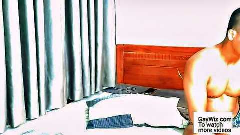 Muscular shirtless gay Asian hunk lounging on hotel bed exposing ripped abs and chest