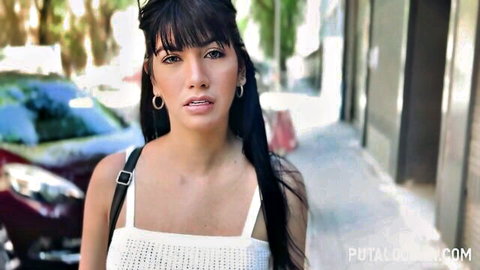 Sexy brunette Latina with long hair posing in sheer white top on street