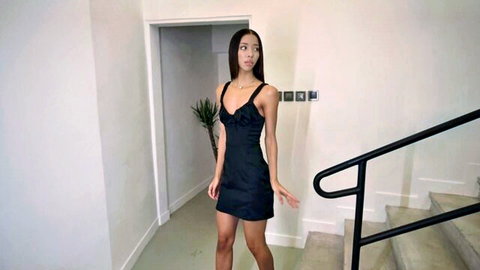 Lia Lin in tight black mini dress, teasing pose in apartment entry