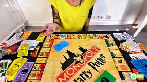Tattooed woman in yellow top playing Harry Potter Monopoly board game