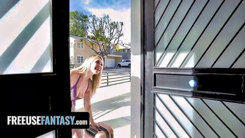 Smiling blonde babe in skimpy purple bikini top teases with cleavage on sunny porch