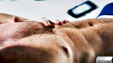 Muscular hairy man Connor Maguire lying down, abs close-up in threesome scene