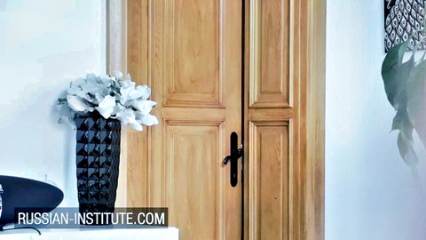 Elegant wooden door with black vase of white flowers in Russian Institute interior
