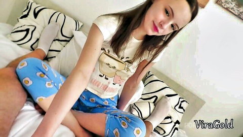 Russian teen in blue pajamas sitting on bed with man's hand on thigh