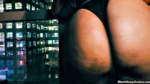 Thick ebony babe's massive black ass cheeks in thong against neon city skyline
