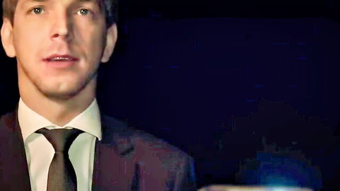 Closeup portrait of handsome young Caucasian man in dark suit with parted lips