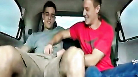 Young gay dude in red shirt gropes his smiling buddy's crotch in open shorts inside car