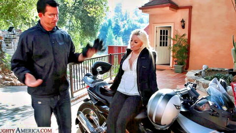 Curvy blonde MILF with big tits sits on motorcycle as tanned guy holds black gloves
