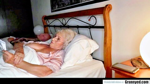 Granny GILF in pink lacy nightgown sleeps in bed with older husband showing cleavage
