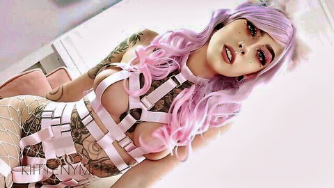 Pink-haired tattooed babe teasing in strappy pink harness lingerie exposing her perky tits and fishnets