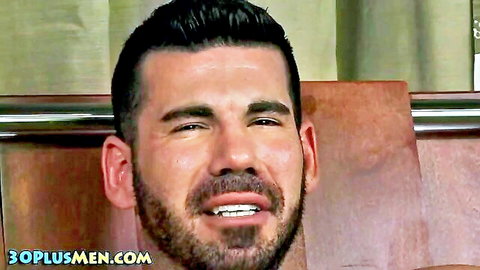 Bearded muscular hunk squints eyes in ecstasy with open mouth during gay blowjob