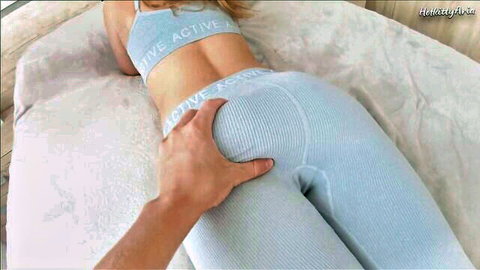 Man gropes fit girl's big round ass in tight blue active leggings on bed