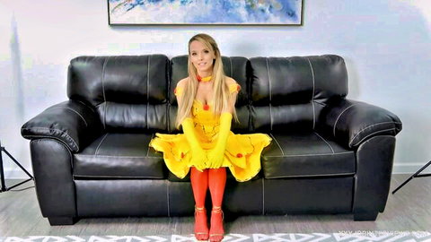 Blonde in sexy yellow Belle costume teasing cleavage and legs on leather couch