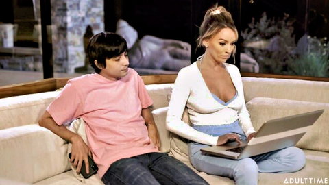 Pristine Edge teases in open cardigan with young boy toy on couch