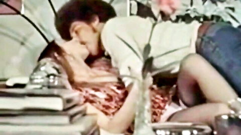 Vintage couple in intimate kissing embrace, man on top of woman in bed