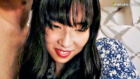 Asian girl with bangs smiles seductively as man nuzzles her neck in intimate couple tease