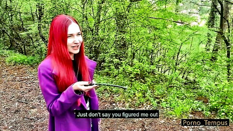 Sexy redhead babe in purple coat smirks teasingly outdoors in forest