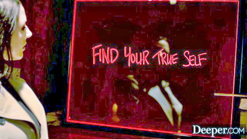 Brunette woman in trench coat gazes at 'Find Your True Self' red neon sign from Deeper.com