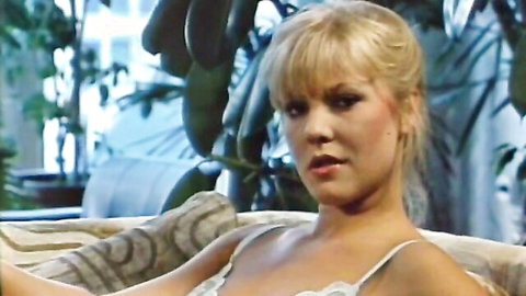 Sultry vintage blonde babe in sheer lace bra with medium tits lounging seductively on couch