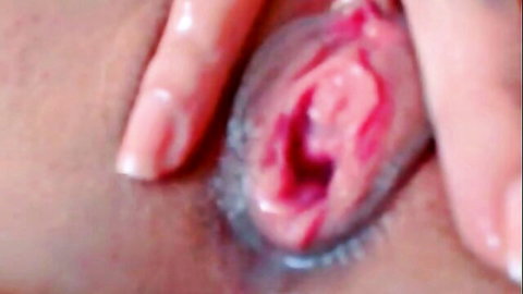 Wet pink pussy spread wide open by fingers exposing glistening inner labia and tight hole