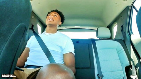 Muscular black stud laughing in car backseat with huge bulge
