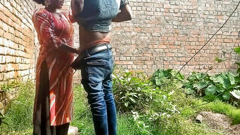 South Asian girlfriend pulls down boyfriend's jeans exposing his ass outdoors against brick wall