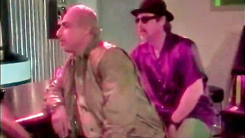 Two men in stylish attire at a bar, mysterious vibe