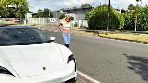 Lara CumKitten in jeans, crop top, high heels, smiling by Porsche in outdoor peeing scene