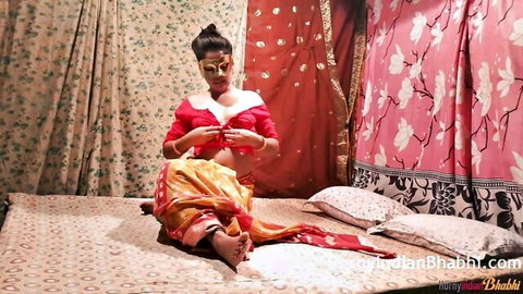 Sexy Desi Bhabhi in red blouse and saree, adjusting outfit seductively