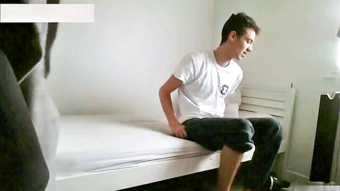 Young amateur guy in white tee and jeans sits on bed, teasing for GF sex tape
