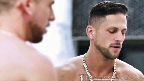 Two shirtless muscular hunks with gold chains and beards in intense close-up trans porn thumbnail
