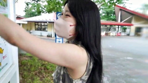 Smiling Asian woman in mask and tank top outdoors for debut