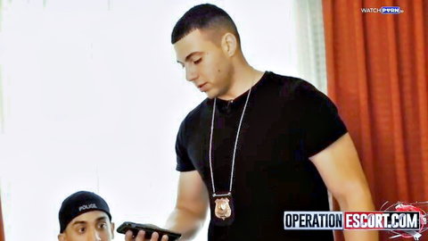 Muscular cop with badge necklace and partner in hat checking phones in escort operation roleplay