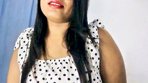 Smiling Indian woman in white polka dot dress with long black hair