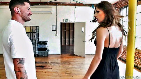 Tanned skinny brunette in black dress seduces tattooed muscular guy in industrial loft