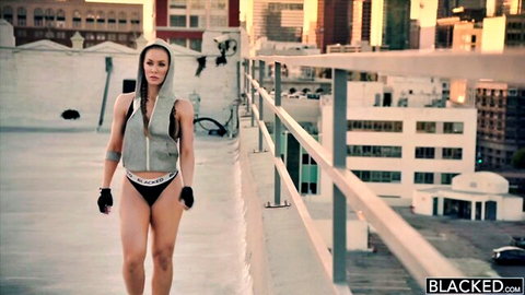 Nicole Aniston in open grey hoodie and black thong on urban rooftop