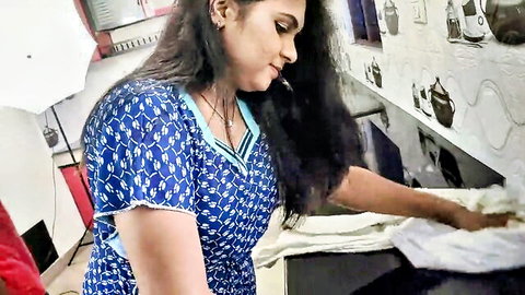 Sexy Indian woman in tight blue dress bending over kitchen counter wiping surface