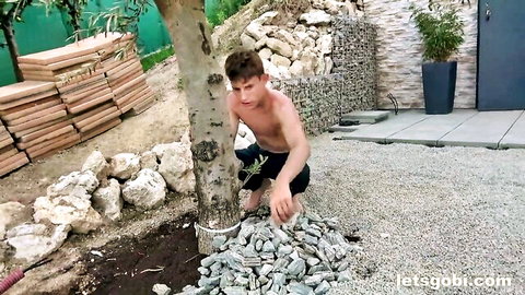 Shirtless twink Jonas Kaizer squatting outdoors in teasing pose for gay gangbang