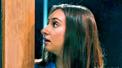 Naughty brunette teen peeking through door with surprised open mouth