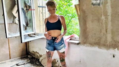 MiaSonne in ripped denim shorts and black crop top, tattooed outdoor solo pose