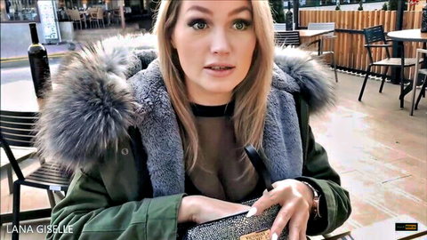 Blonde Lana-Giselle in sheer top and fur-trimmed parka outdoors