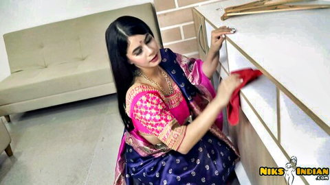 Curvy Indian woman in pink choli and blue saree bending over teasingly