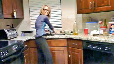 Blonde bombshell in tight top and pants teasing in kitchen