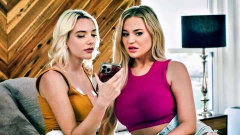 Two blonde friends in tight tank tops sharing a phone intimately