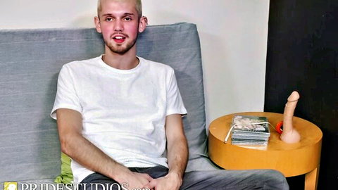 Christian Aces sits casually with dildo, teasing anal play with blonde friend