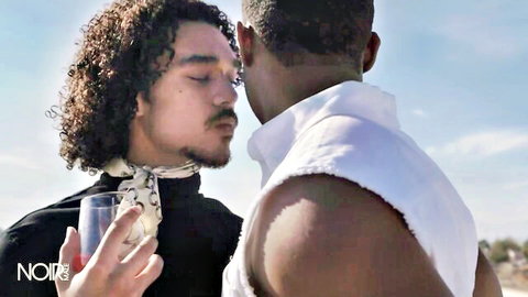 DeAngelo Jackson and Derek Cline close embrace outdoors, muscular black men