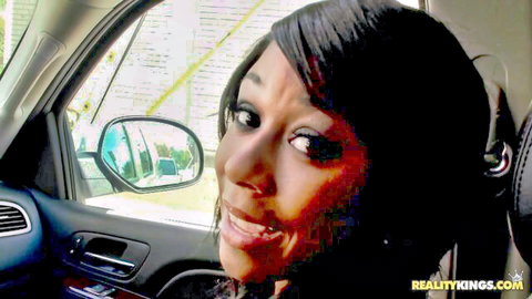 Petite ebony Megan Vaughn smiling in car, ready for outdoor tattoo and fuck
