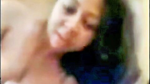 Busty dark-skinned babe giving a steamy blowjob close-up